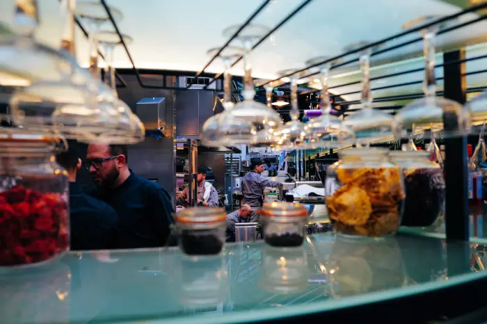 Ingredient jars looking into an active restaurant kitchen.
